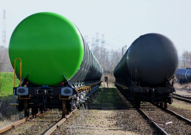 green and black tanker cars on train rail tracks stock photo