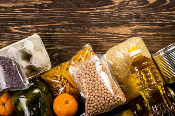 Food donations in box in kitchen background Food donations in box in kitchen background, copy space basic food stock pictures, royalty-free photos & images