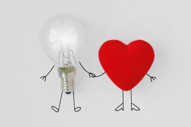 light bulb and heart holding hands - concept of brain and heart teamwork - coherence imagens e fotografias de stock