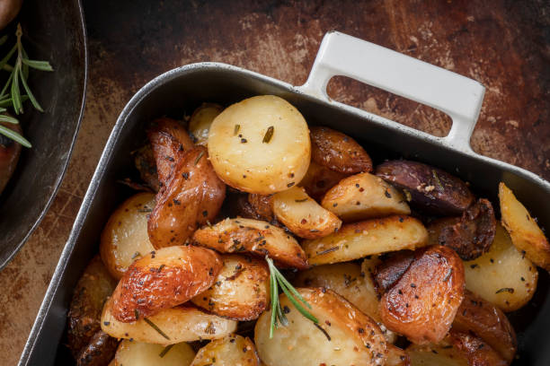 patata asada - roasted potatoes prepared potato herb food fotografías e imágenes de stock