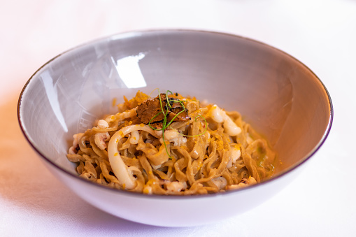 Delicious Italian buckwheat pasta (pasta di grano saraceno) with squid and truffle. Italian recipe. Selective focus.