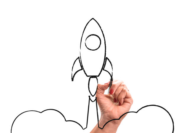 istock woman hand with pencil draws Rocket launch. 1075037250