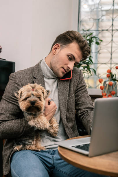 istock Busy man holding a dog while working 1075041268