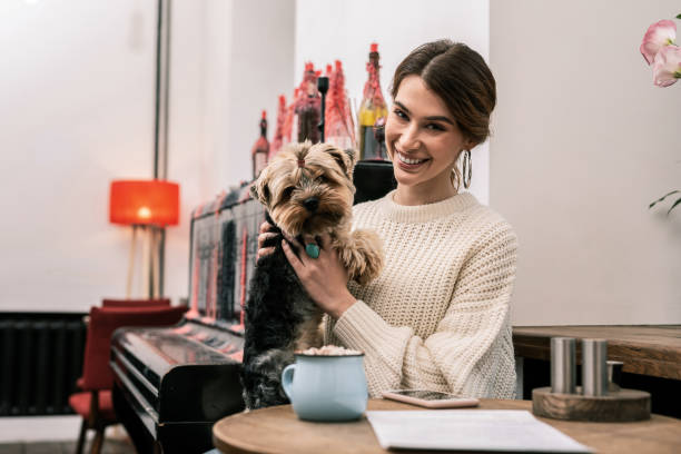 istock Smiling woman visiting the cafe with her dog 1075041386