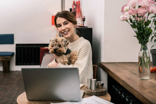 istock Smiling woman hugging her dog while working 1075041402