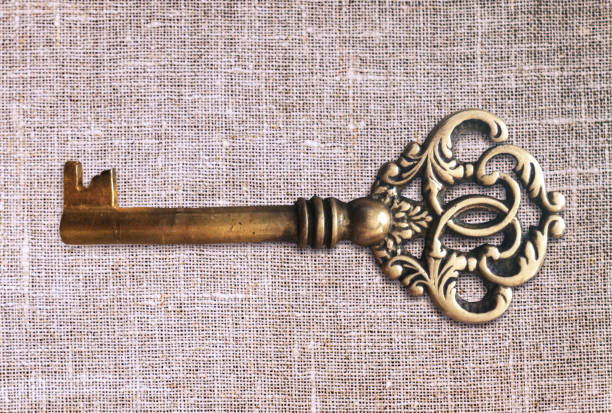 istock Vintage key on linen fabric. Crown shaped chest key. 1075051904