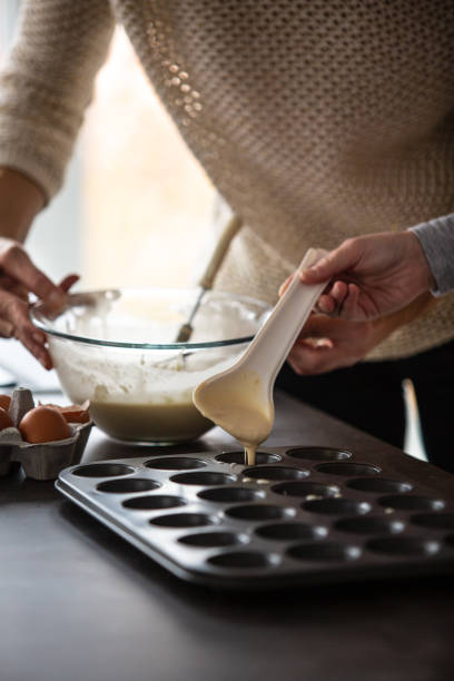istock Mother and daughter baking muffins 1075052530