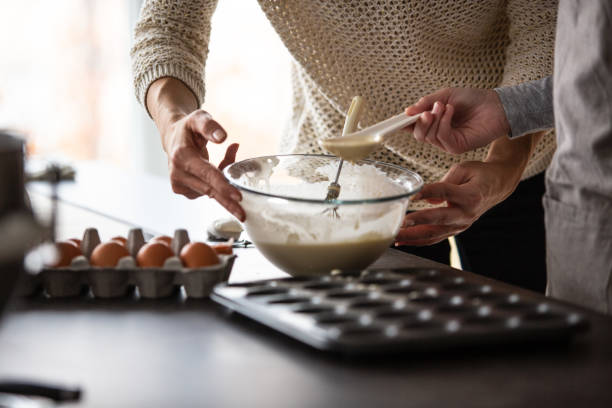 istock Mother and daughter baking muffins 1075052650