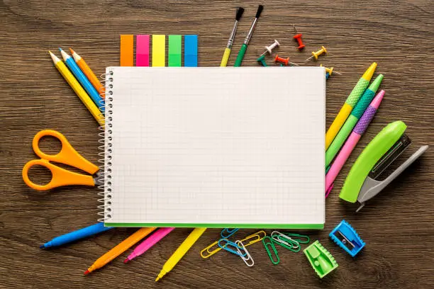Bright school accessories, stationery on a wooden background.