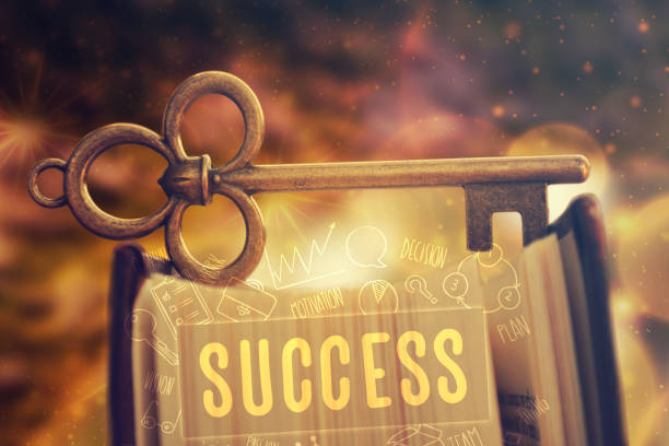 Old key standing on the book. Motivational concept, success background.