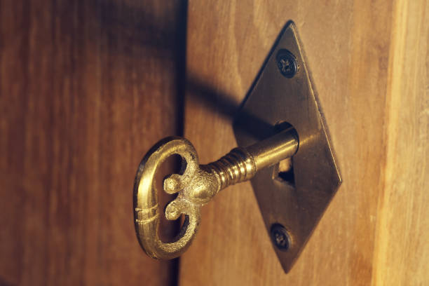 istock Old keyhole with key on a wooden door. 1075057062