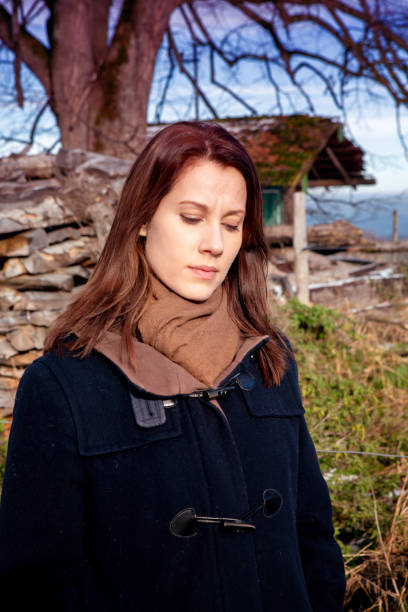 istock brunette young woman standing outdoors and looking sad 1075060448