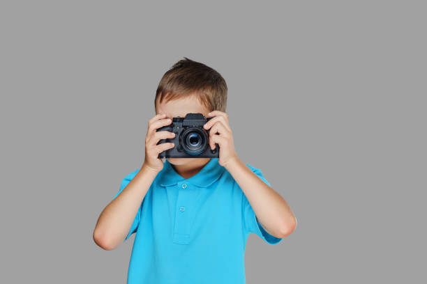 istock A boy taking pictures with a professional camera. 1075070246