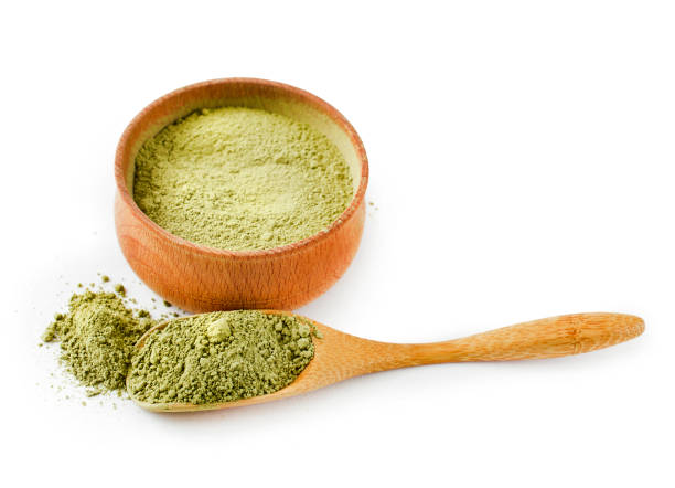Matcha Tea Dry Matcha Tea in a wooden cup and scoop isolated on white background. Top view. green tea powder stock pictures, royalty-free photos & images