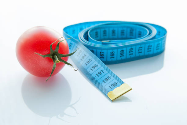 測定テープとジューシーなトマト、減量と健康的な栄養の概念 - instrument of measurement vegetable measuring exercising ストックフォトと画像