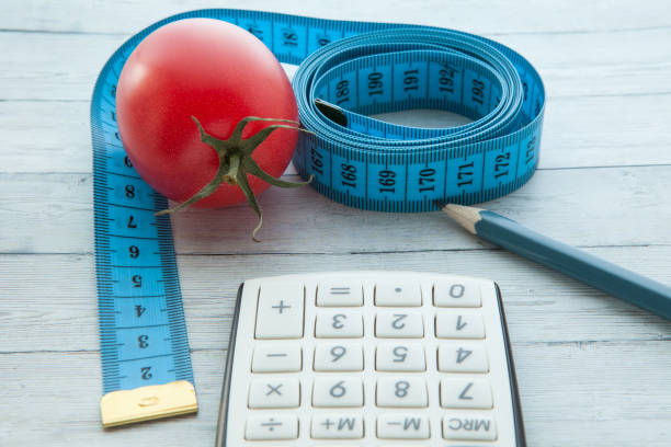 測定テープとジューシーなトマト、健康的な食事と痩身、クローズ アップの概念と計算 - instrument of measurement vegetable measuring exercising ストックフォトと画像