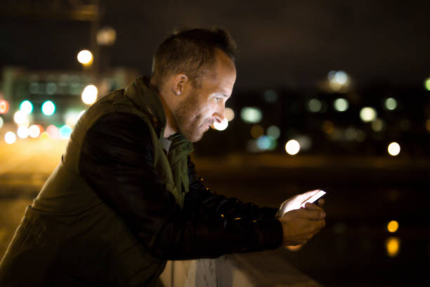 istock Handsome man using smart phone mobile in the city at night 1075079252