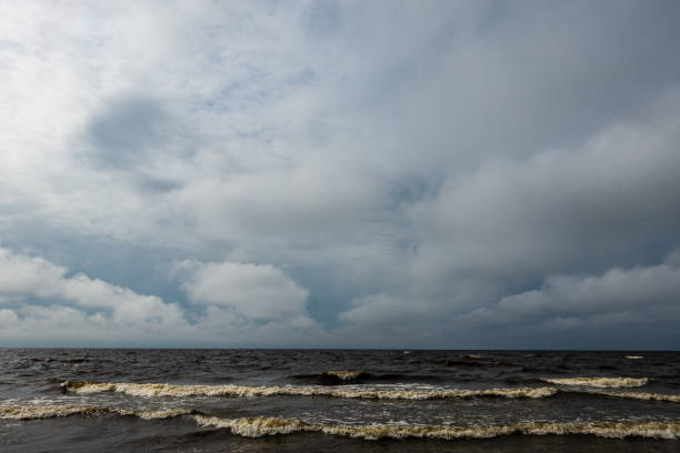 istock storm clouds forming over clear sea beach with rocks and clear sand 1075093716