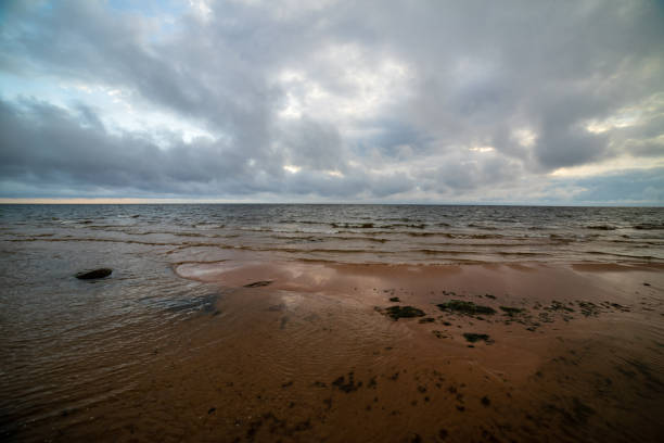 storm clouds forming over clear sea beach with rocks and clear sand. dramatic colors