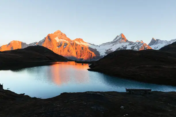 Picturesque view on Bachalpsee lake in Swiss Alps mountains. Snowy peaks of Wetterhorn, Mittelhorn and Rosenhorn on background. Grindelwald valley, Switzerland. Landscape photography