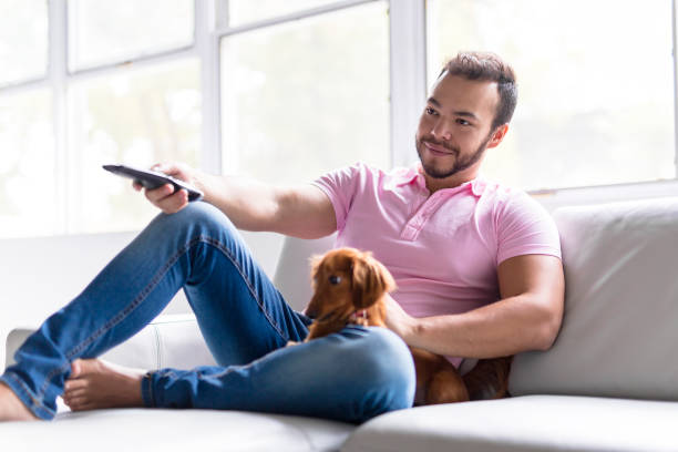 istock Young attractive mexican man at home sitting on couch 1075100578