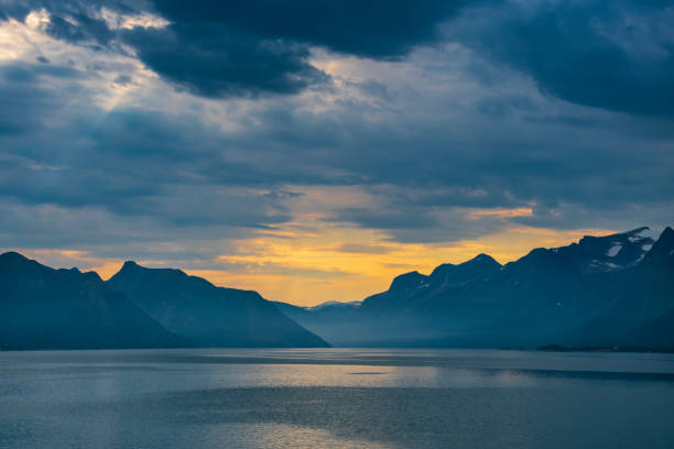 Scenic view from a cruise ship of the midnight sun as it sails through the Lofoten Islands on the coast of Norway.