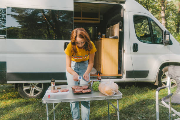 istock Woman cooking burger on grill in forest 1075106282