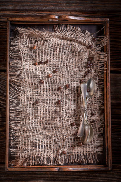 istock Old burlap doily and coffee beans on rustic wooden tray 1075106302
