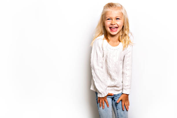 Studio portrait of cute blonde girl laughing to the camera.