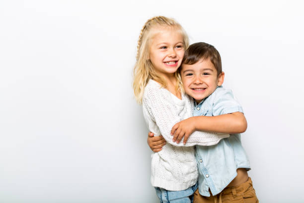 istock Cute girl 4-5 year old with brother posing in studio 1075108718