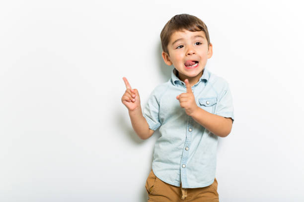 muchacho que se divierten en fondo de estudio gris - niño pequeño fotografías e imágenes de stock