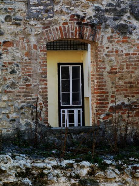 istock old decaying brick wall with opening and building beyond 1075109046