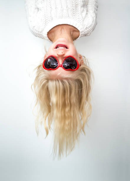 istock Cute girl 4-5 year old posing in studio upside down with love glasses 1075109170