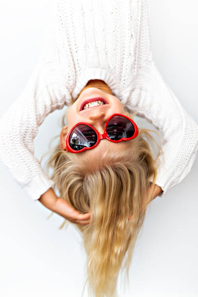 istock Cute girl 4-5 year old posing in studio upside down with love glasses 1075109352