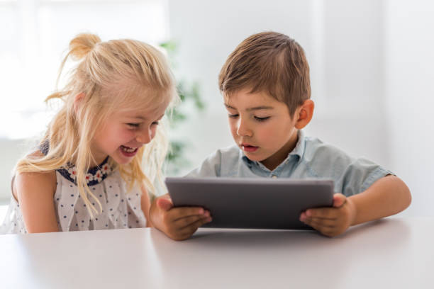 istock Adorable brother and sister young child using tablet 1075109670