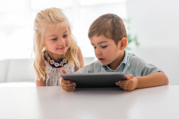 istock Adorable brother and sister young child using tablet 1075109804