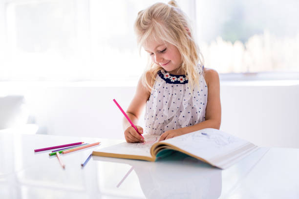istock little girl drawing in the kitchen table 1075110314