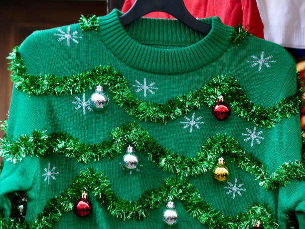 schön oder hässlich: grüne weihnachten pullover mit dekor-kugeln - weihnachtspullover stock-fotos und bilder