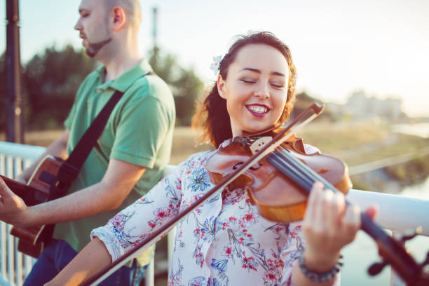 músicos con violín y guitarra - violin women violinist music fotografías e imágenes de stock