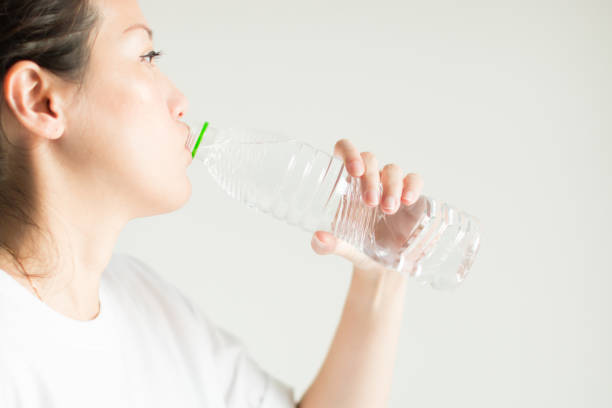 istock A woman drinking water from plastic bottle. 1075154226