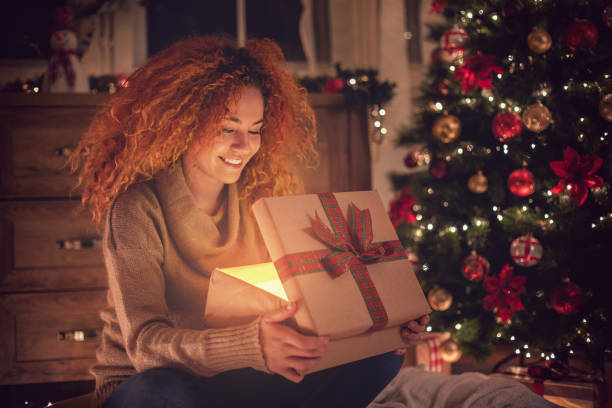istock Young Beautiful Girl With Present in a Cozy Christmas Atmosphere 1075154708