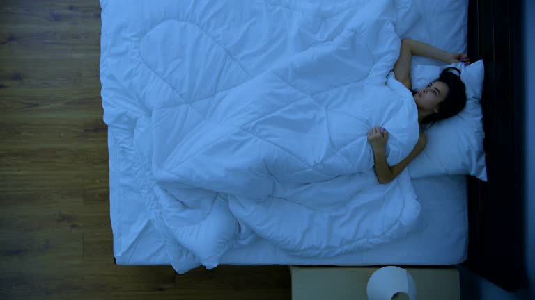 The woman with an insomnia laying on the bed. view from above. night time