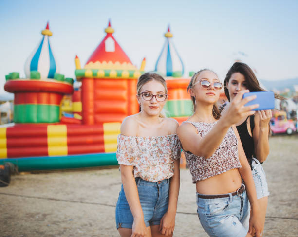 istock Girls taking selfies by inflatable castle 1075160516