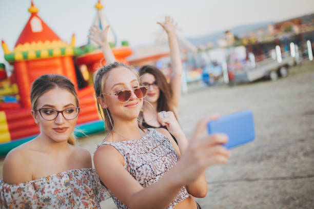 istock Girls taking selfies by inflatable castle 1075166430