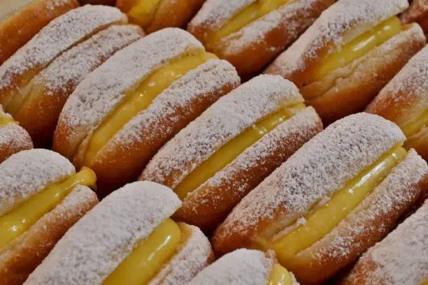 Photo of Traditional Italian pastry - krapfen - filled with pasticcera cream - for sale in Christmas kiosks everywhere in Italy.