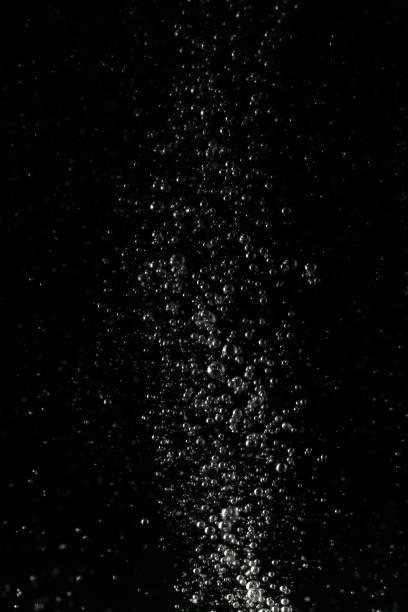Black and white explosion of bubbles moving in water stock photo