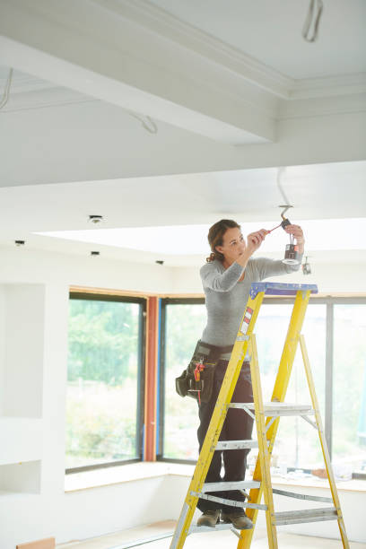 istock female electrician installing downlights 1075177690