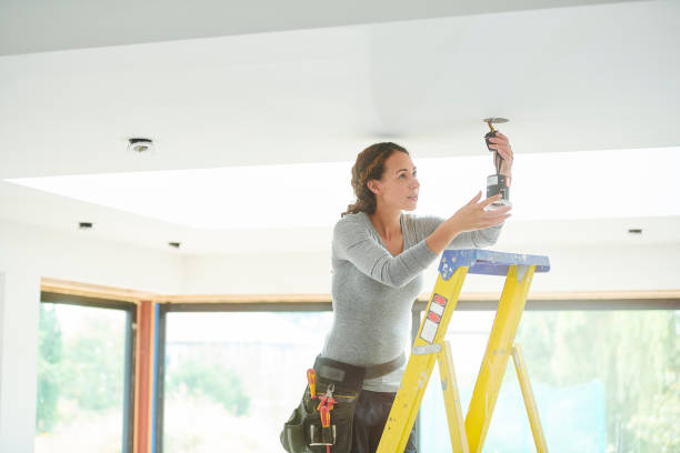 elettricista donna installazione downlight - window installing repairing construction foto e immagini stock