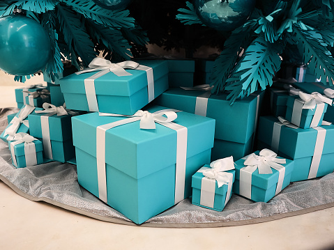 Shot of a group of boxes with presents under a decorated Christmas tree