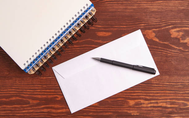 istock envelopes and notebook on wooden background 1075186280